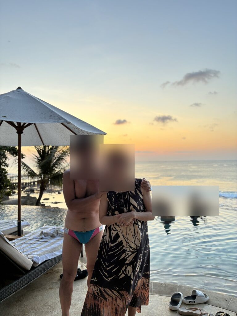 オーシャンビーチプールの縁で夕陽を待つ夫婦