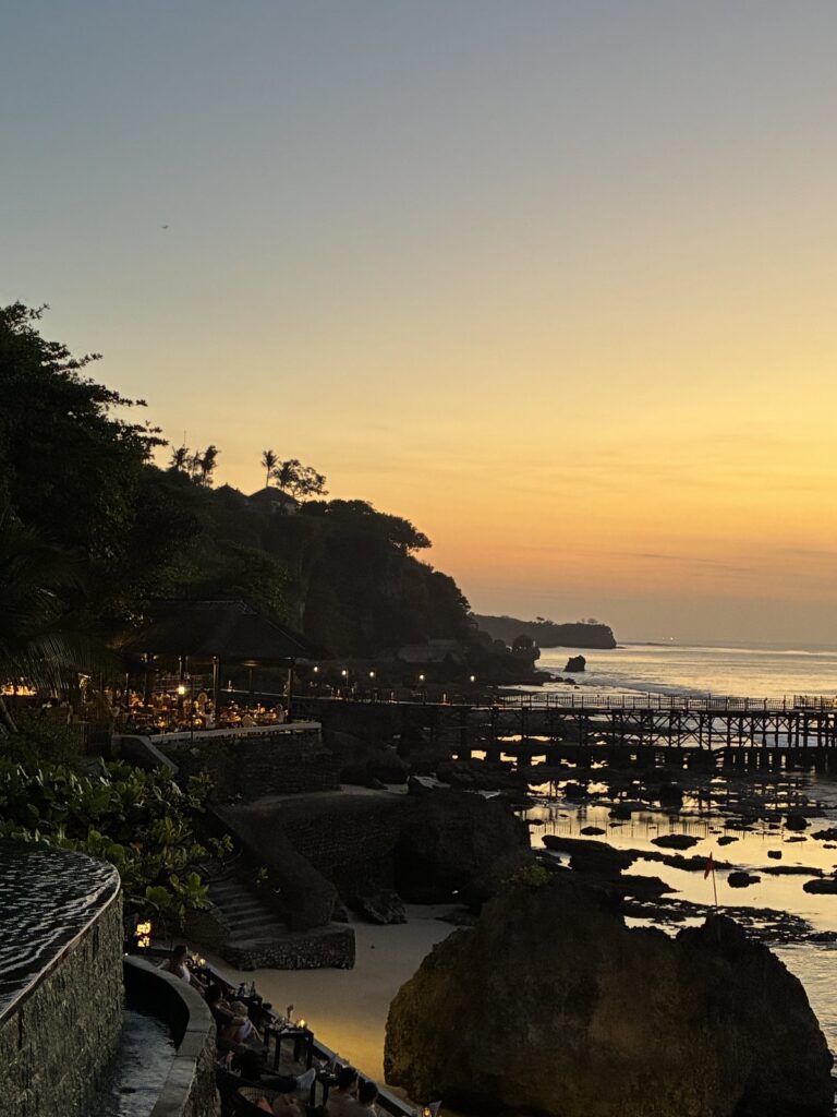 崖の下のロックバーと桟橋、夕焼けの海